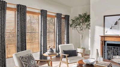 Living room windows with wood blinds and patterned curtains