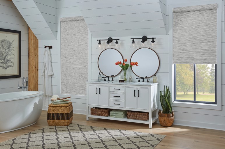 Bathroom vanity with two windows on each side that have roller shades on them